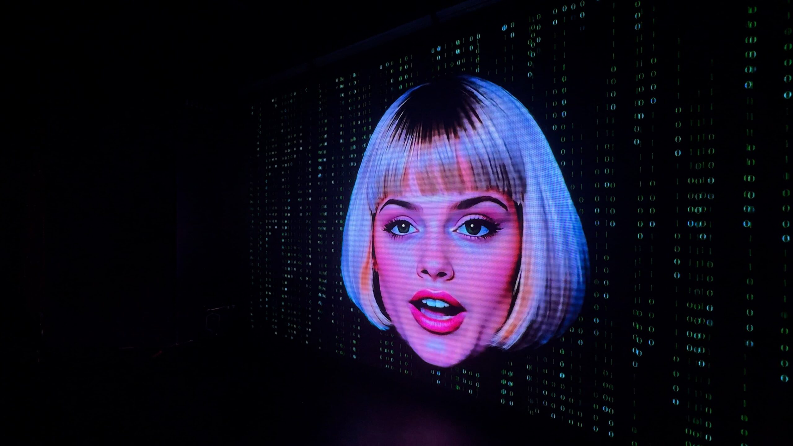 L.I.L.A., the LAZER CORP A.I. character, appearing to read the audience during the HACKED show